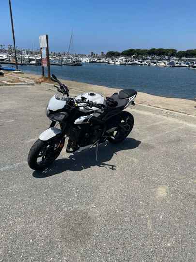 Bundit's white 2024 Triumph Street Triple R parked by the marina in Southern California